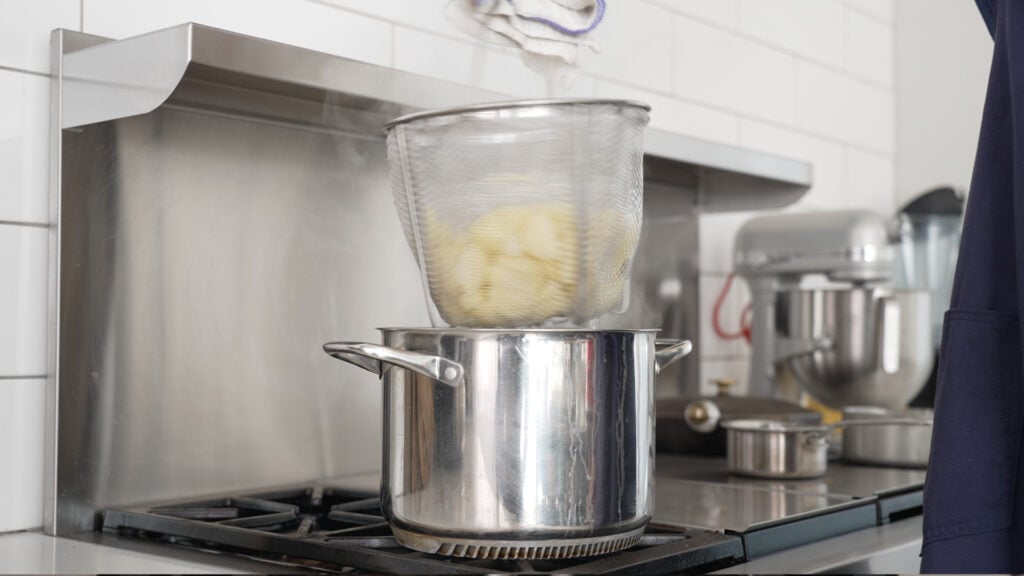 Lifting the basket insert out of the pot of water