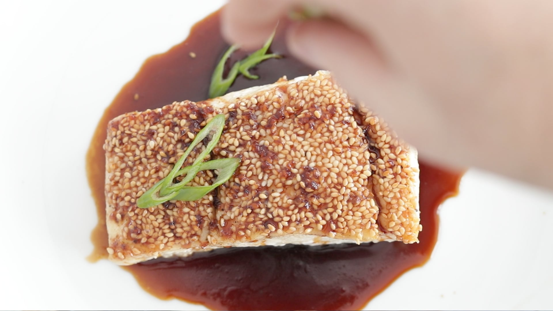 garnishing a halibut with green onions