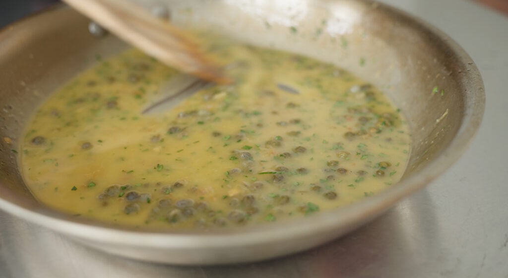 Stirring the sauce with a wooden spoon