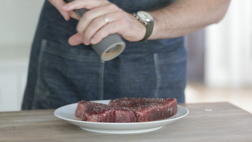 seasoning fresh tuna with salt and pepper
