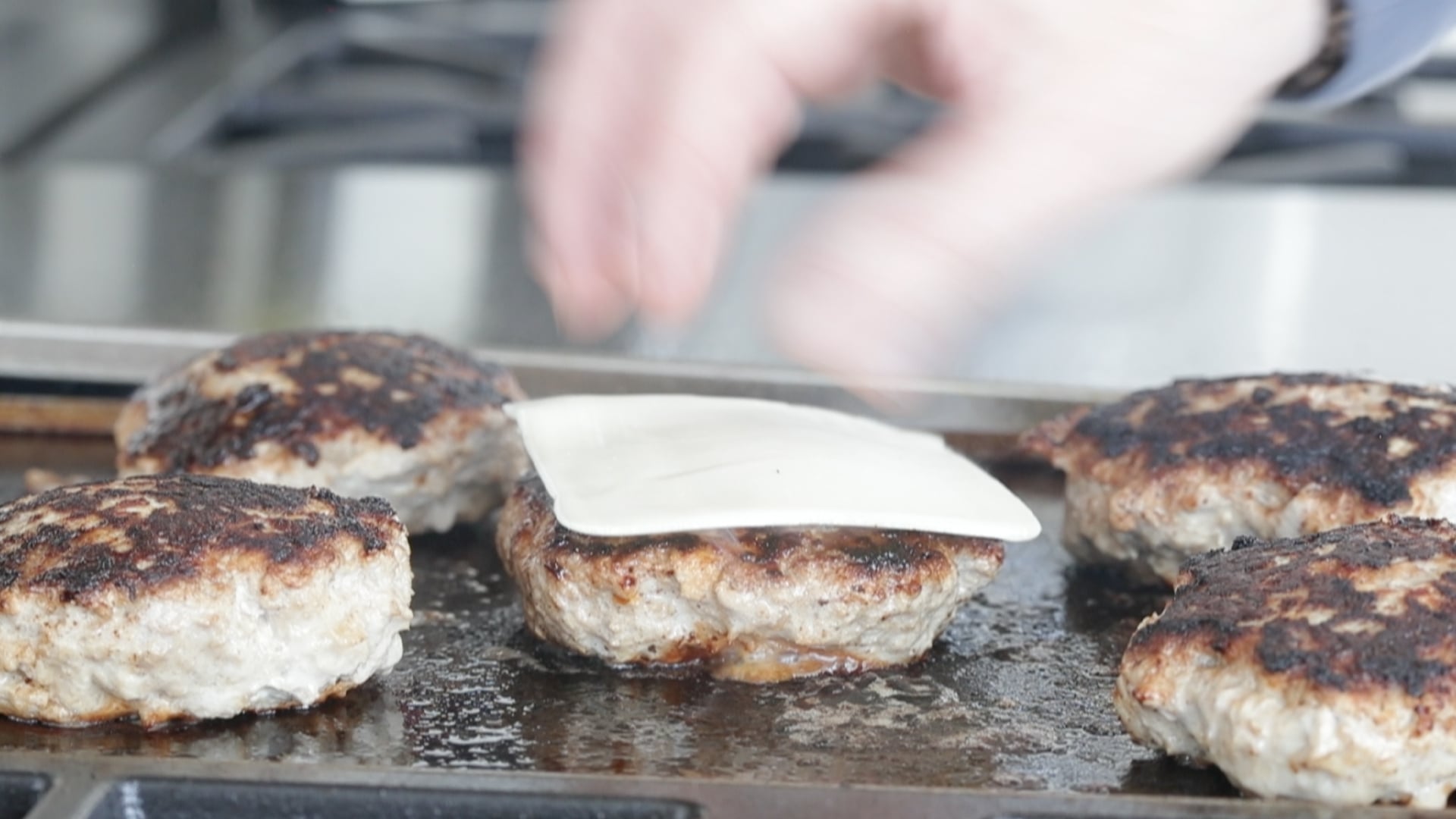adding cheese to a turkey burger