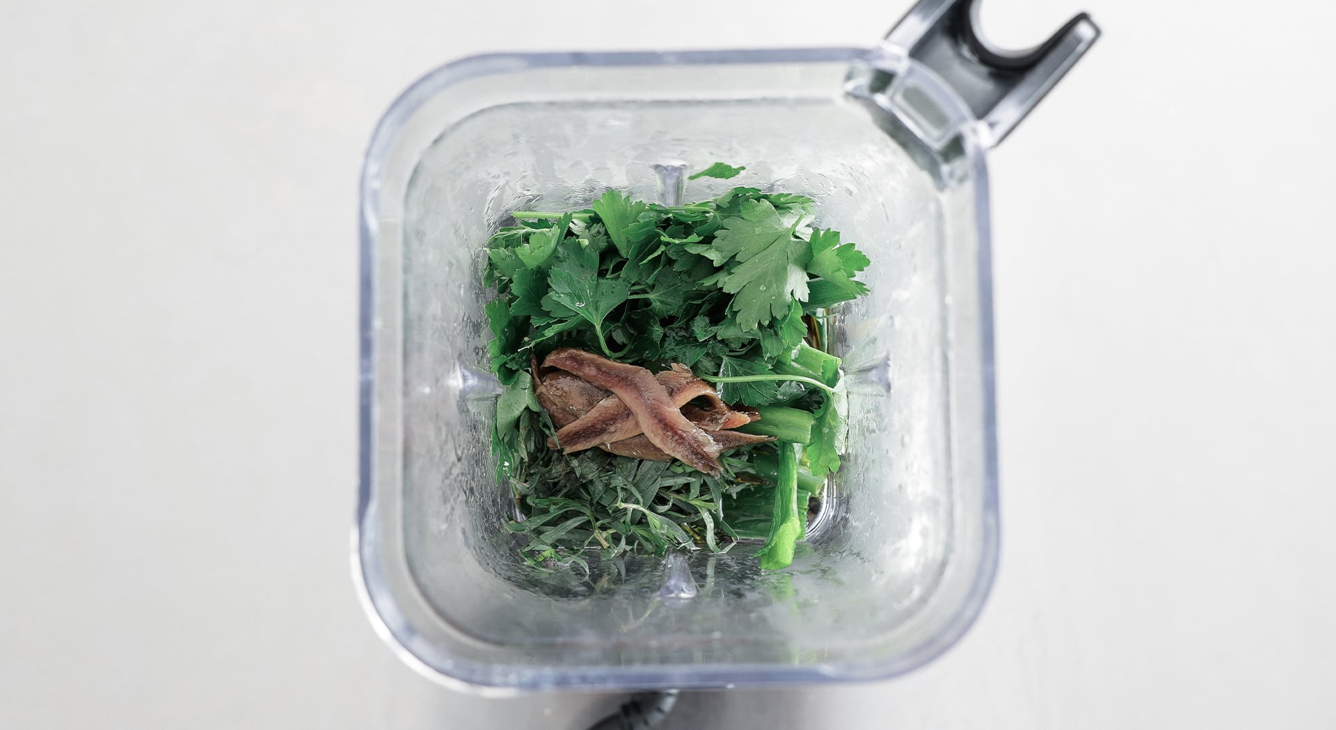 anchoives and herbs in a blender