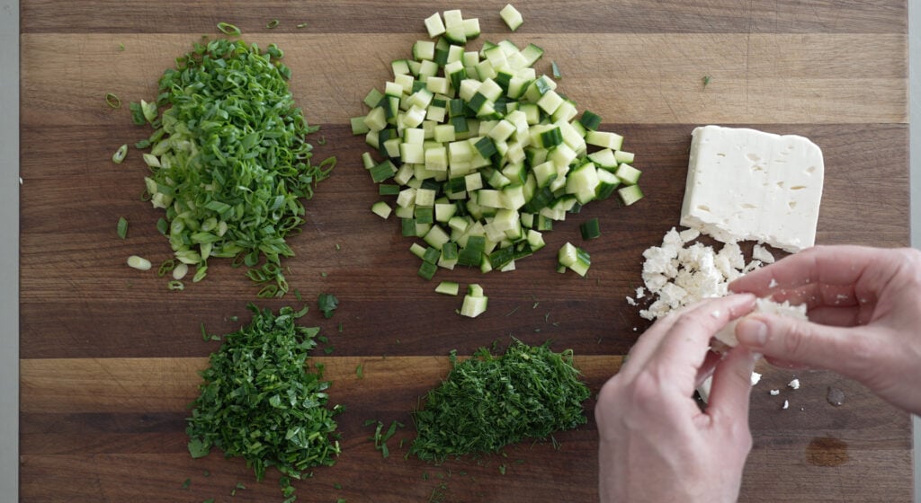 maroulosalata ingredients diced on a wooden cutting board