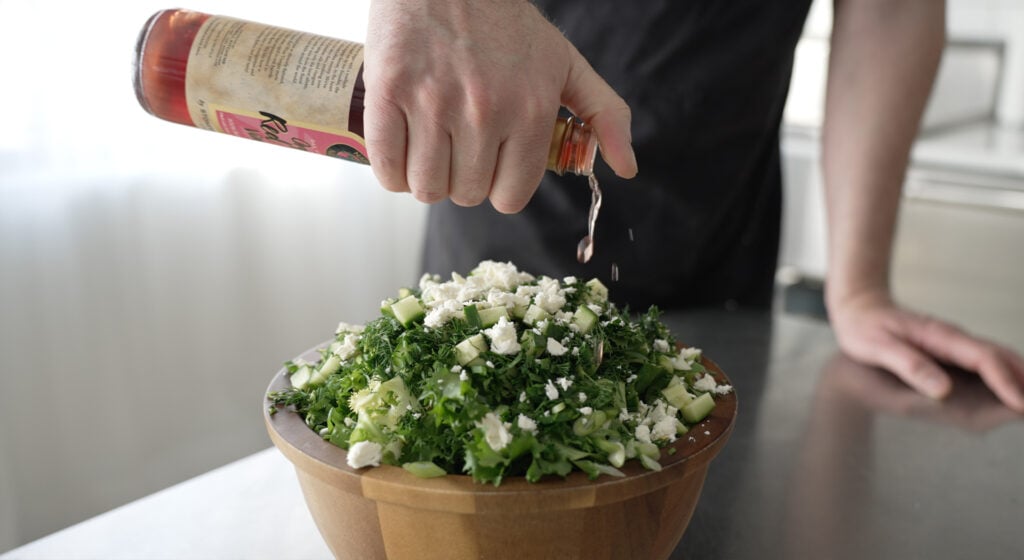 sprinkling red wine vinegar on top of the salad