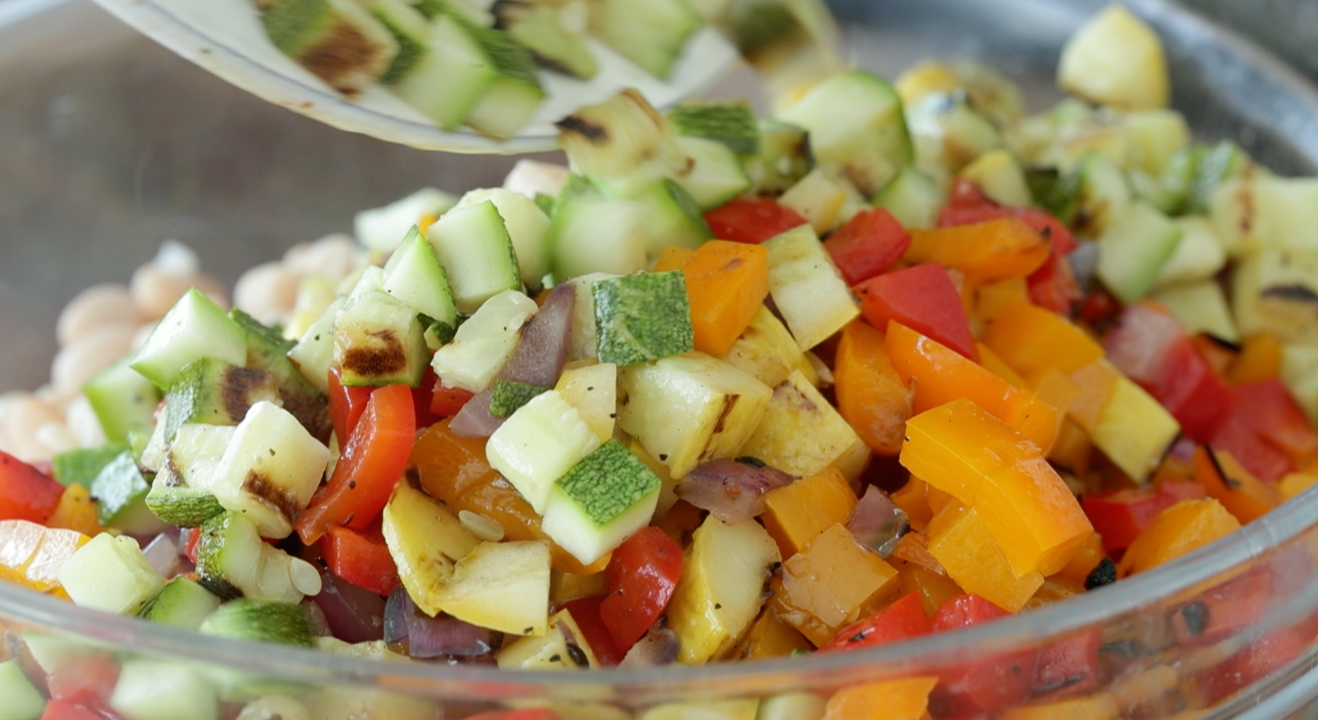 adding cooked vegetables to a bowl