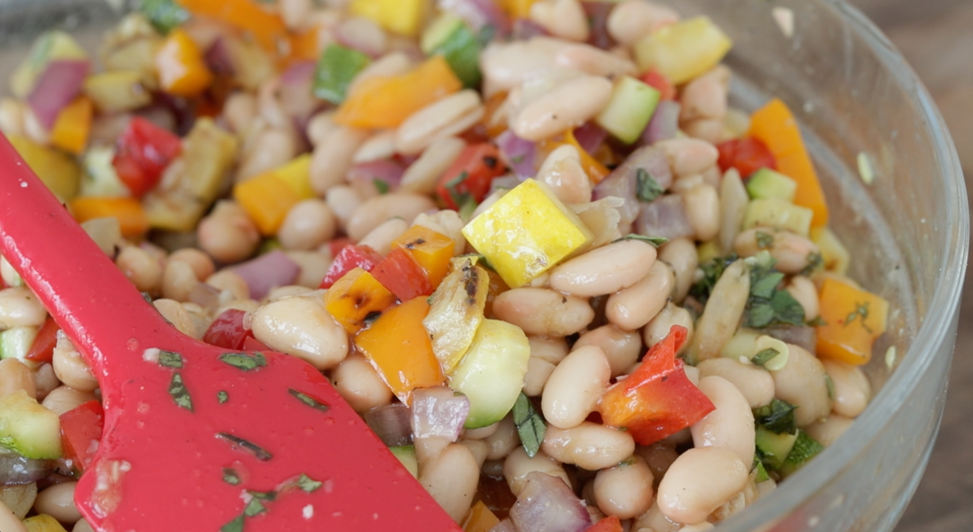 mixing a mediterranean bean salad