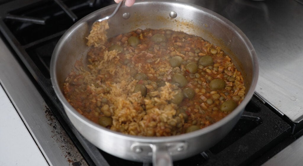 Cooked, uncovered arroz con gandules in a pot on the stove