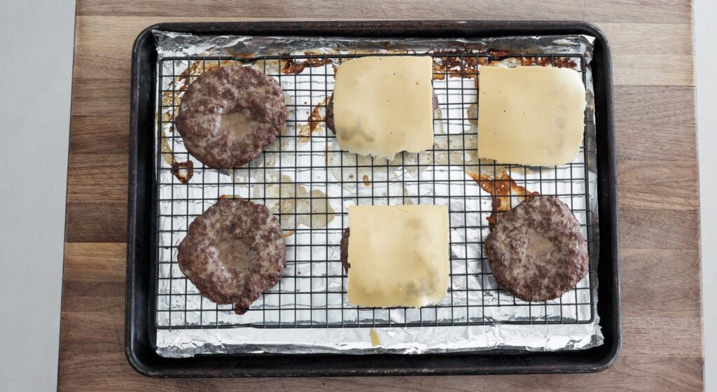 6 burger patties, 3 with a slice of cheese and 3 with no cheese added