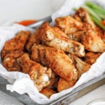 baked wings on a tray with celery and carrot sticks