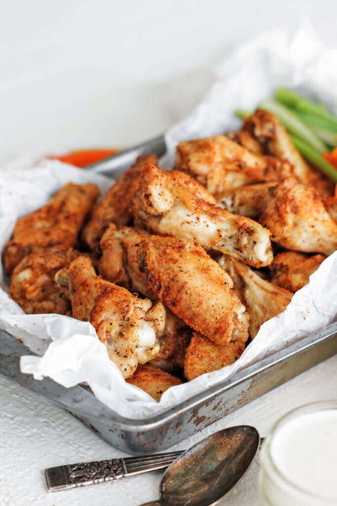 baked wings on a tray with celery and carrot sticks