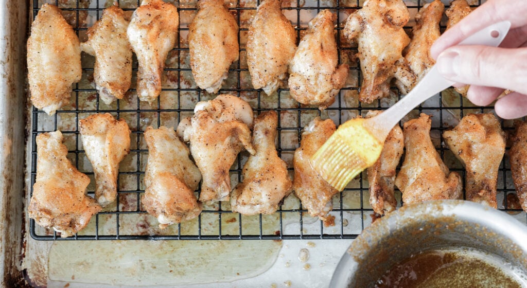 brushing seasoned butter on baked wings