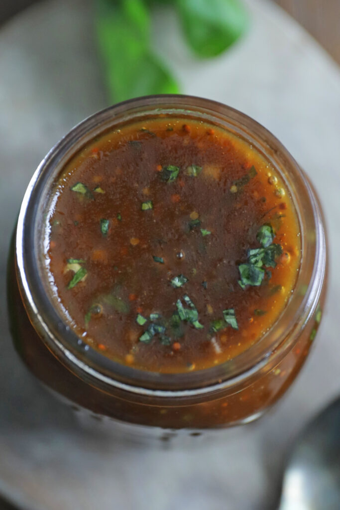 balsamic vinaigrette recipe in a jar with fresh chopped basil