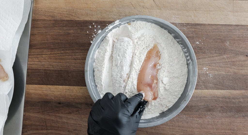 chicken in a shallow round pan coated with flour