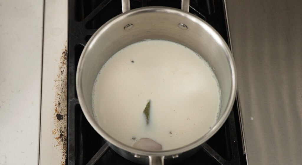 Overhead view of pan with milk and shallot
