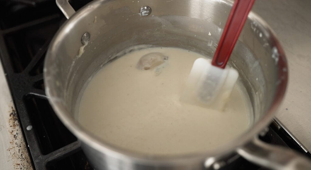 using a rubber spatula to stir ingredients in a pot