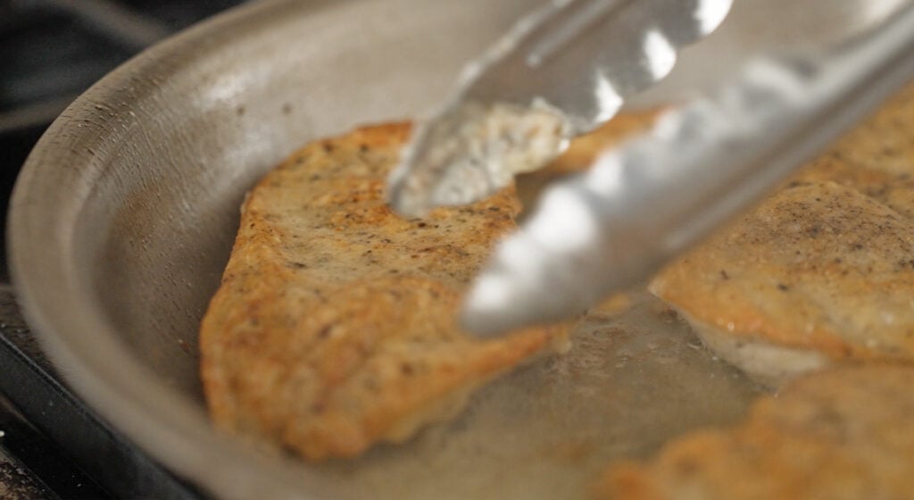 golden brown chicken breast in a pan
