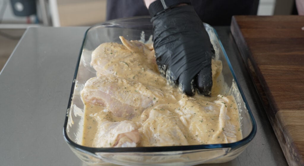 raw chicken in a glass dish covered with marinade