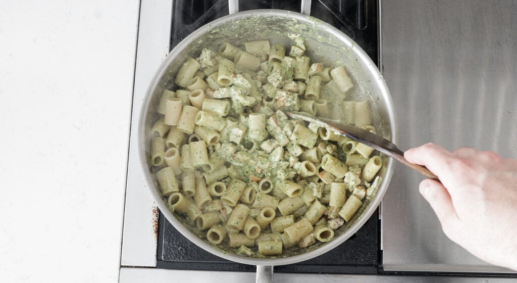 the compined pasta being stirred with a kitchen utensil