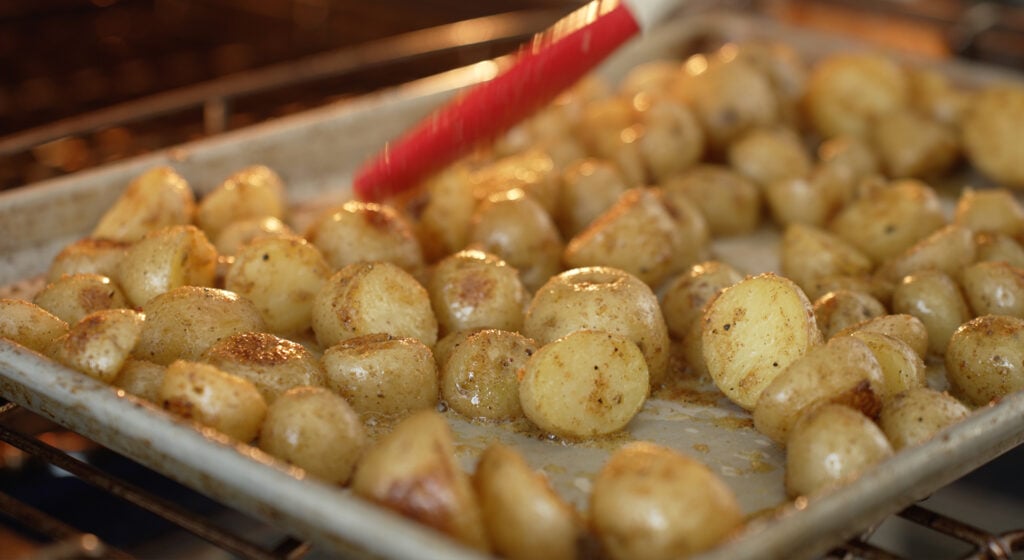 potatoes cooking in the oven on a sheet tray