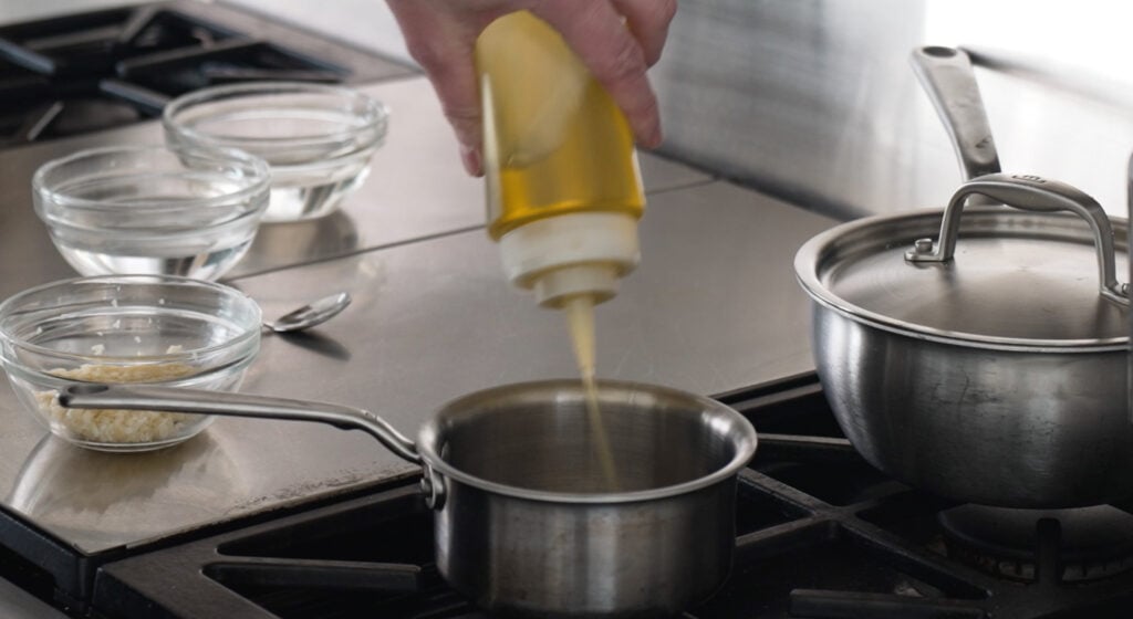 Pouring oil in a pan on the stove 

