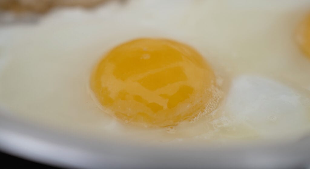 Close up of egg cracked in a pan