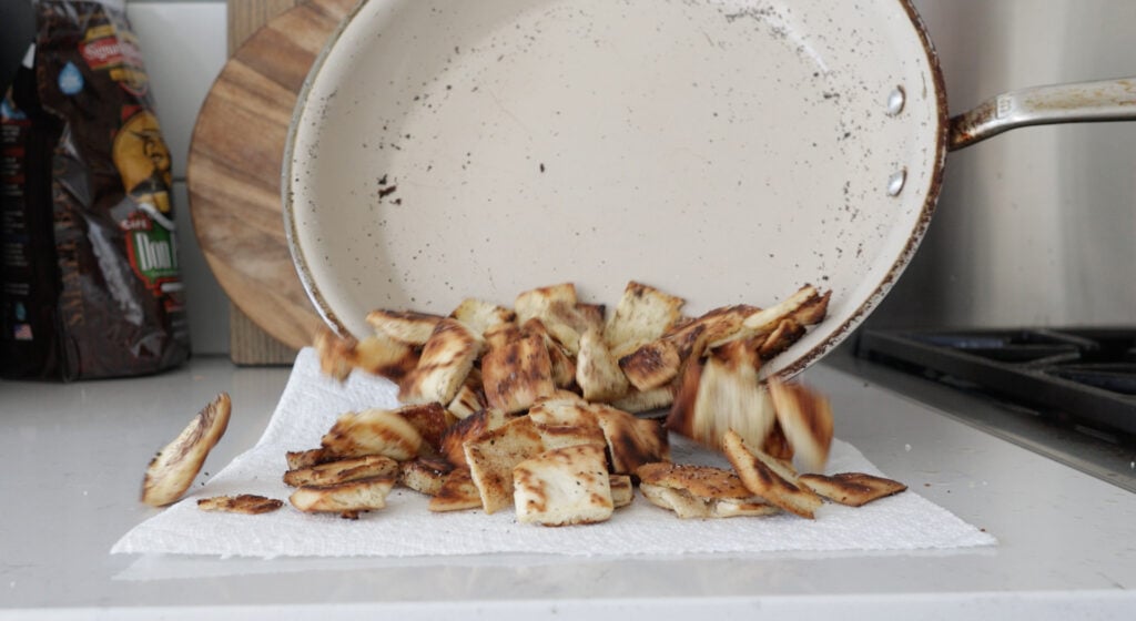Pouring browned pita on a paper towel