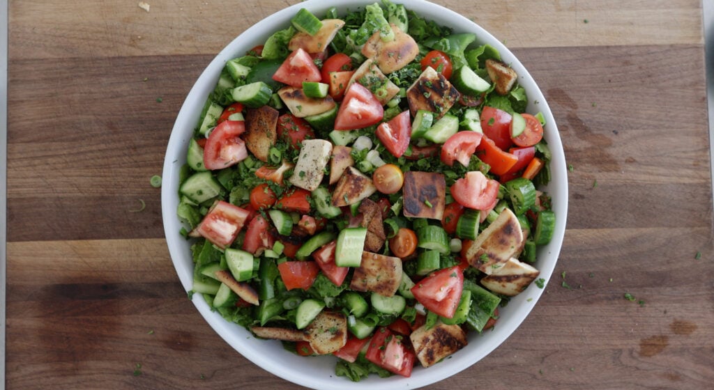 Veggetables sprinkled over the top of the greens