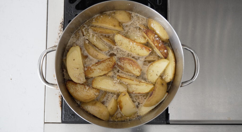 overhead view of browned potatoes on the stove in a rondeau