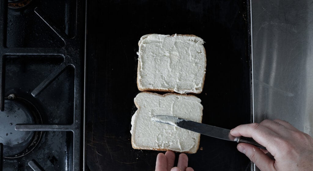 Spreading butter mayo mixture on the second side of each piece of bread