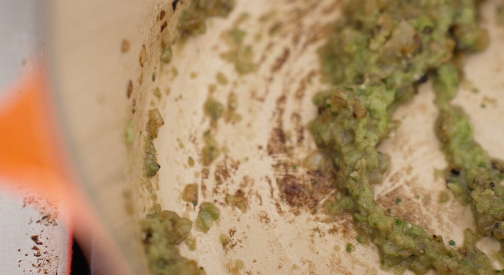 Close up of pan with sofrito and garlic added to the pieces of onion