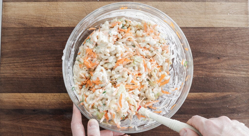 using a rubber spatula to stir all of the ingredients together in a glass bowl
