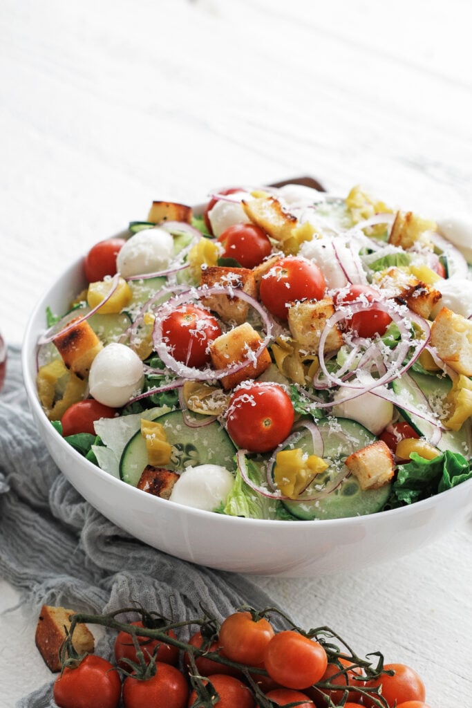 Mixed greens salad in a white serving bowl