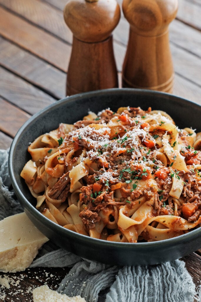 Lamb ragu on a table in a black serving bowl