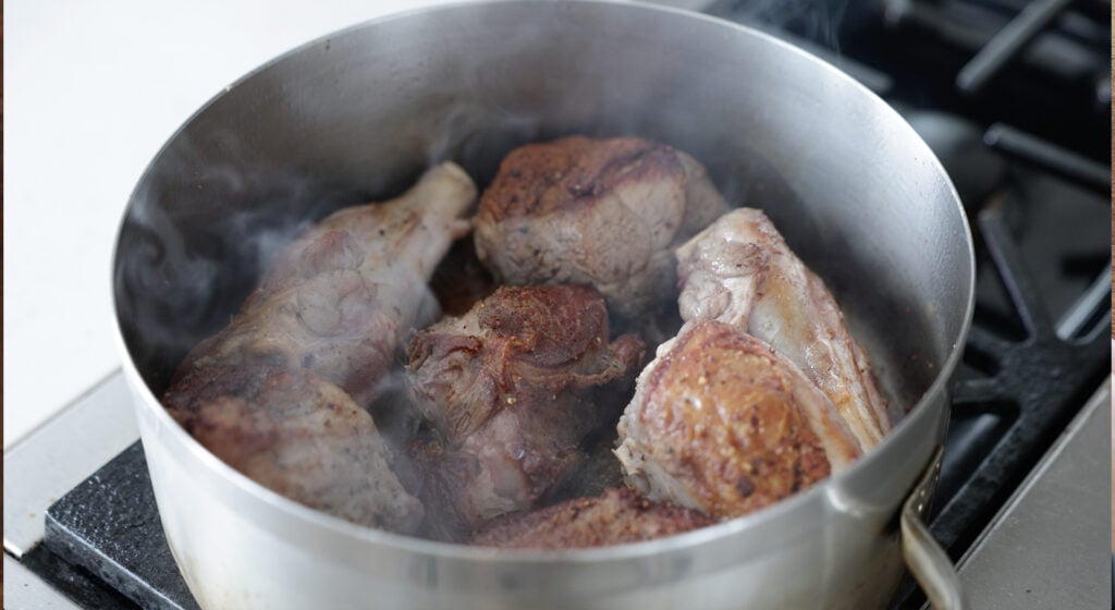 Browned lamb pieces in a large pot