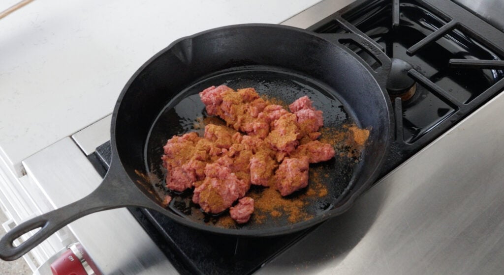 Ground beef browning in the skillet with seasoning