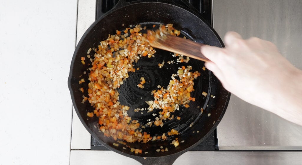 Peppers and garlic added to the onions in the skillet