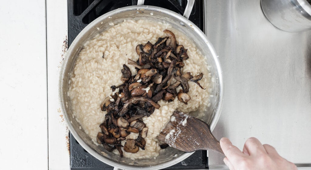 folding mushrooms into the risotto