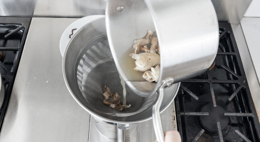 Straining the mushroom trimmings from the stock