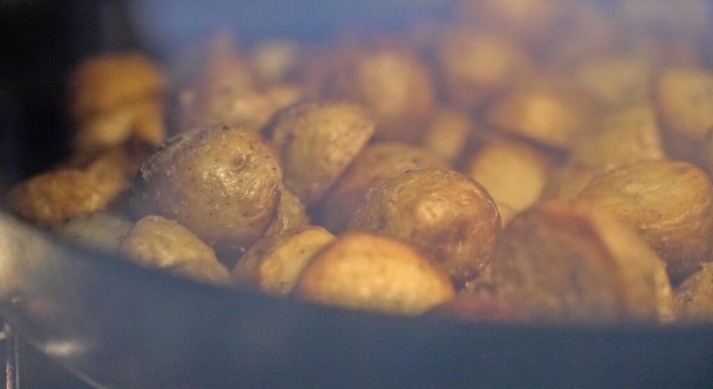 Close up of potatoes roasting in the oven