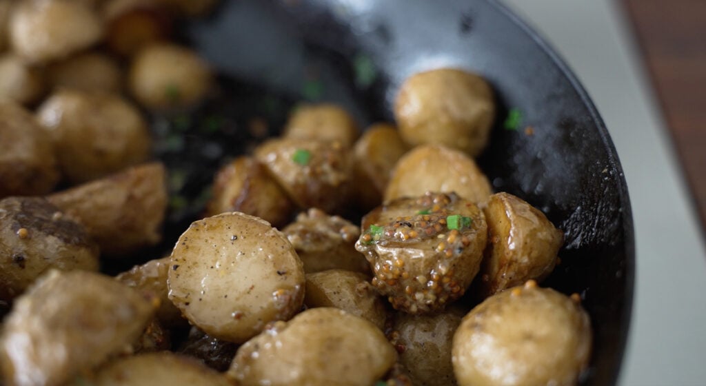 Cooked potatoes drizzled with mustard and butter sauce