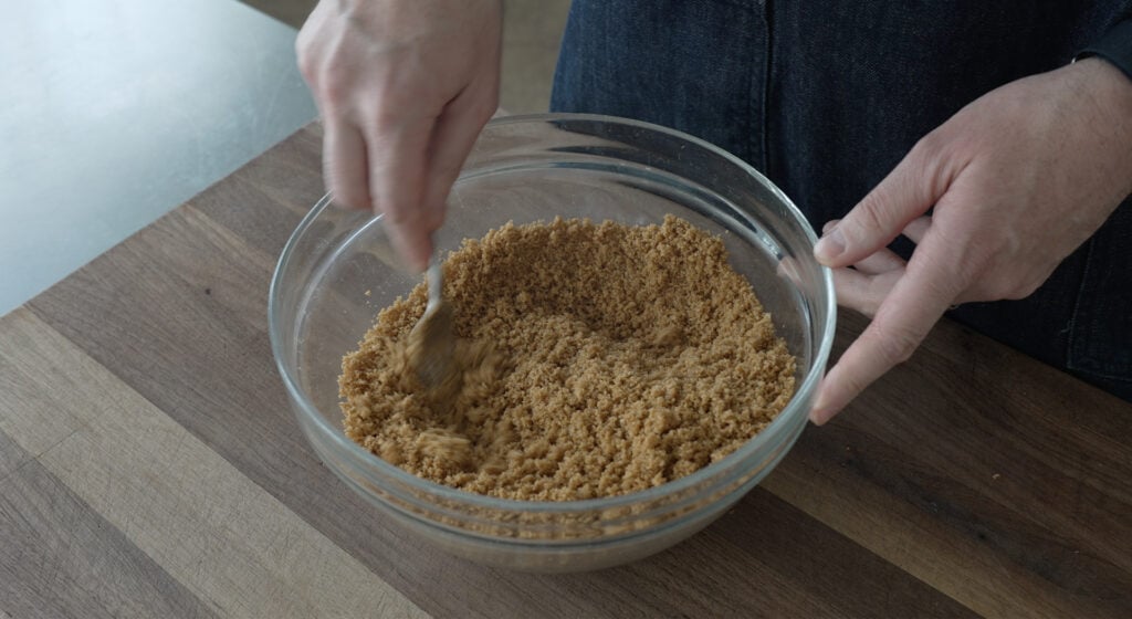 stirring crust ingredients together in a bowl with a fork