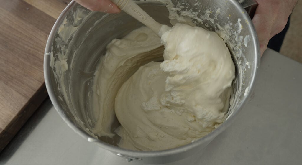 A close up of the mixing bowl with smooth cheesecake filling inside