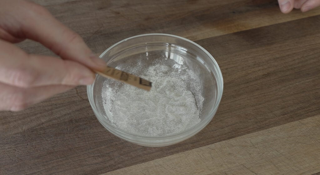 Adding gelatin powder to a small glass bowl