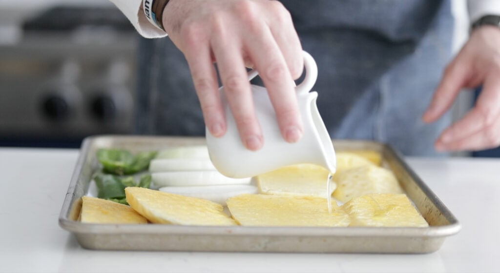 drizzling olive oil on sliced vegetables