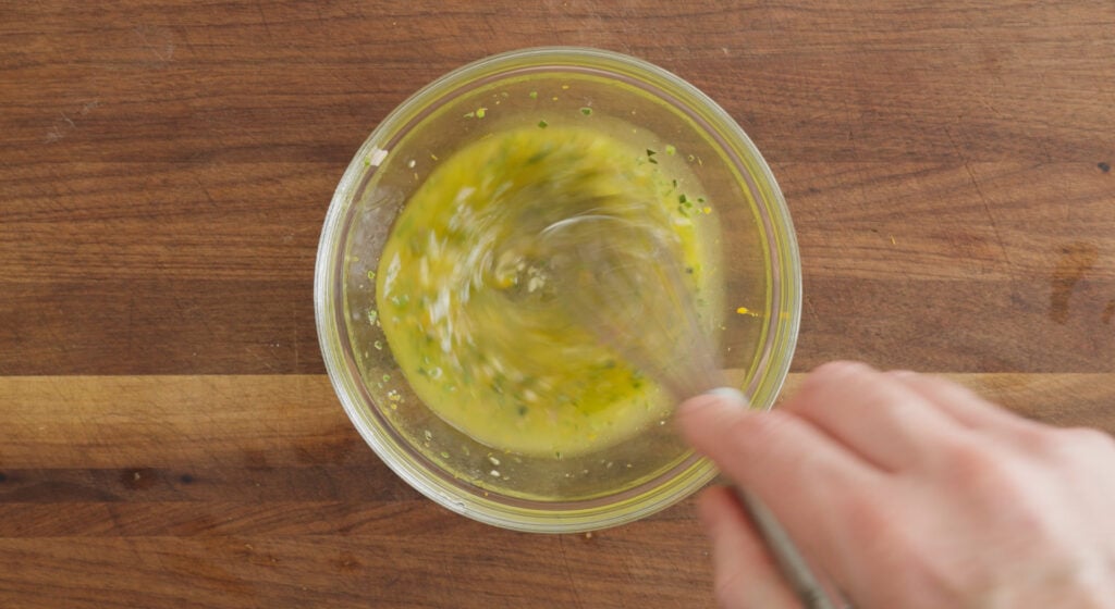 whisking ingredients in a small glass bowl