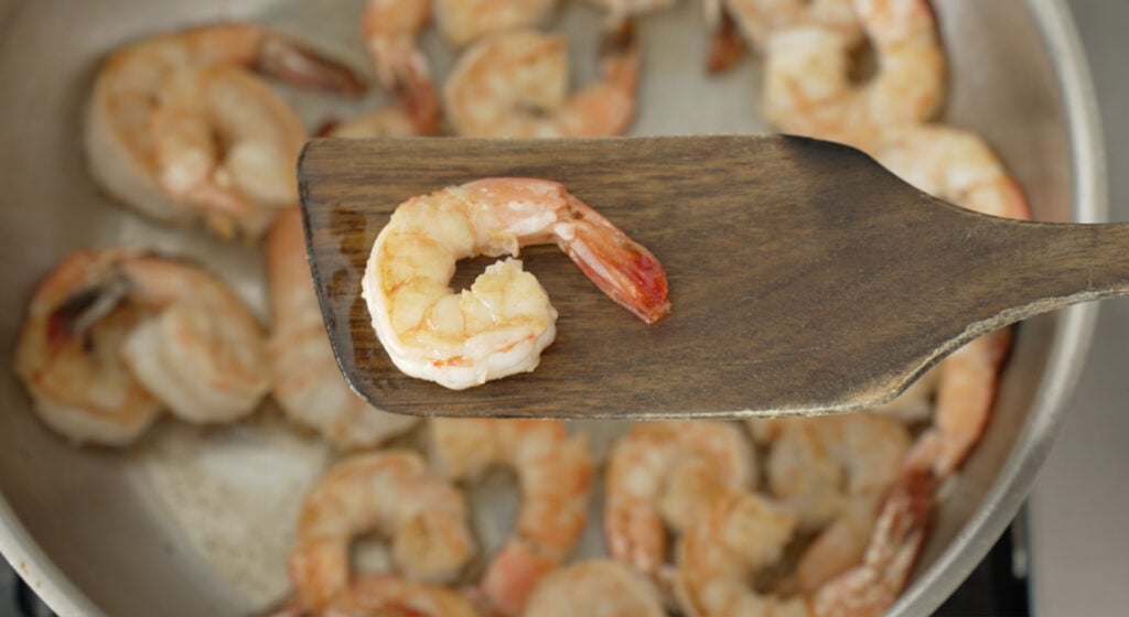 cooked shrimp on a wooden utensil