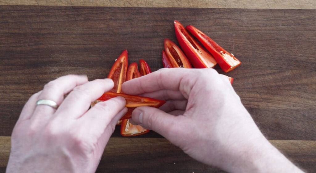 using fingers to remove seeds from peppers