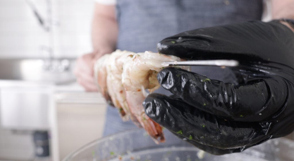 thredding shrimp onto a skewer