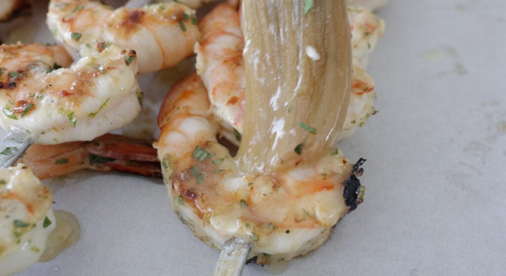 Brushing butter marinade sauce on the cooked shrimp
