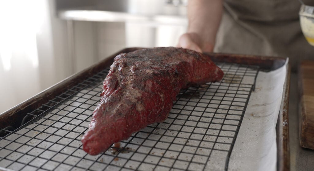 finished smoked tri tip on a rack, over a sheet tray